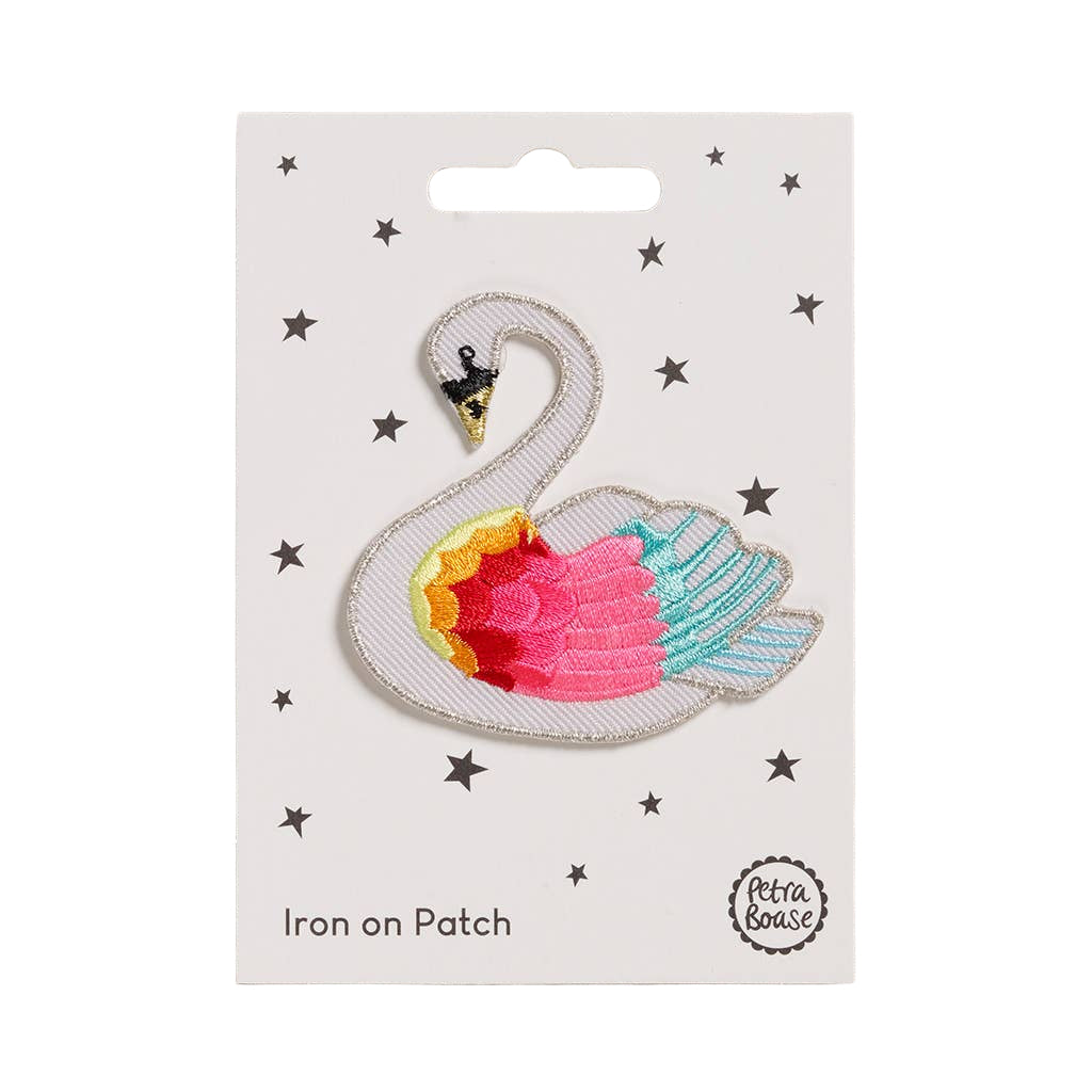 Iron on patch of a swan with colorful body on a white card with star patterns